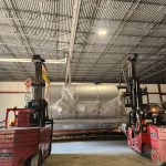 Two IRH forklifts work in tandem to safely move production equipment.