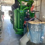 An IRH crew member standing next to a generator.