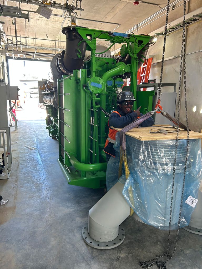 An IRH crew member standing next to a generator.
