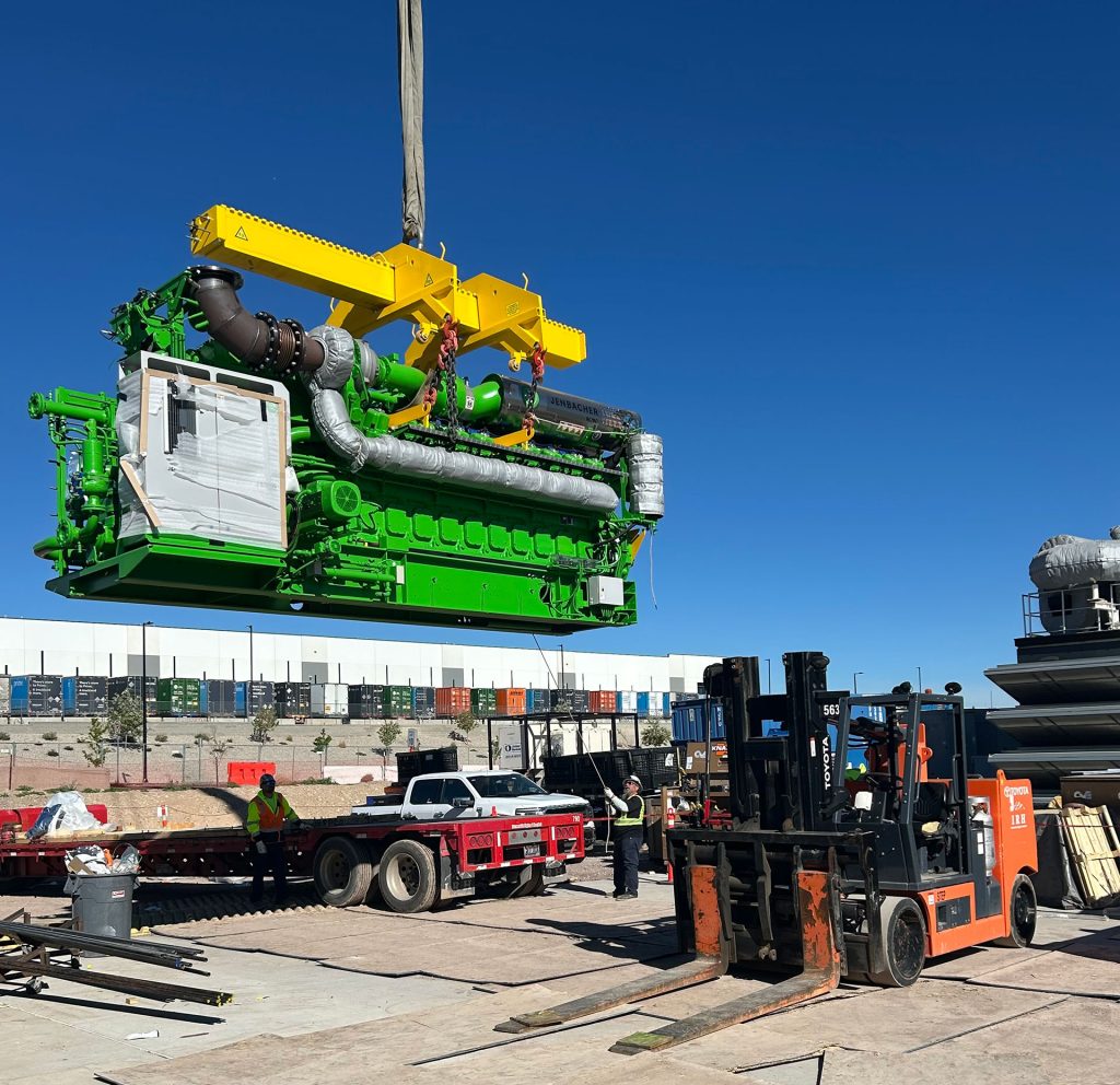 IRH crew member holding a tag line while a 275-ton crane lifts a generator.