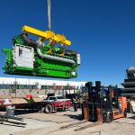 IRH crew member holding a tag line while a 275-ton crane lifts a generator.
